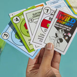Hand holding Monopoly game cards with a blue background